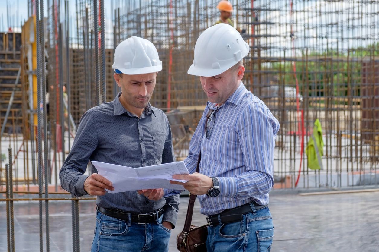 fm=f_xV2pdAG Foreman and the contractor are looking at the project on the construction site. Teamwork concept.